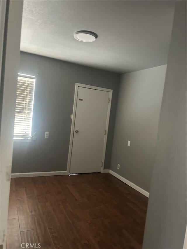 foyer entrance with wood finished floors and baseboards
