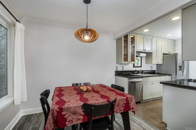 dining space with crown molding, dark hardwood / wood-style floors, and sink