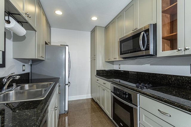 kitchen featuring dark stone countertops, sink, gray cabinets, and appliances with stainless steel finishes