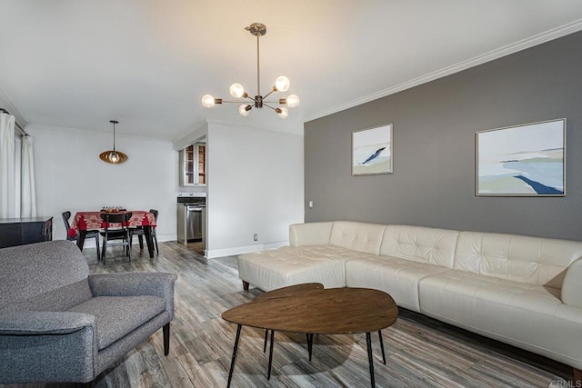 living room with wood-type flooring, a notable chandelier, and crown molding