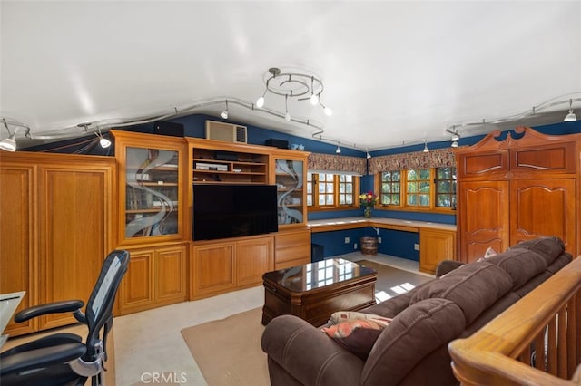 living room featuring lofted ceiling and built in desk