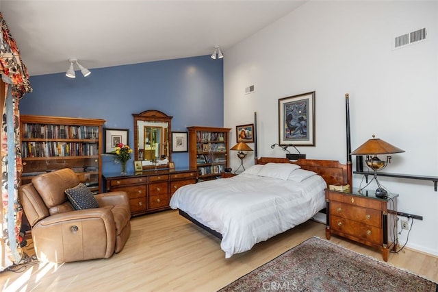 bedroom featuring light hardwood / wood-style flooring and high vaulted ceiling