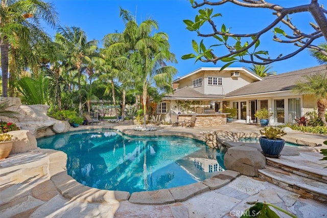 view of swimming pool with a patio area and an outdoor bar