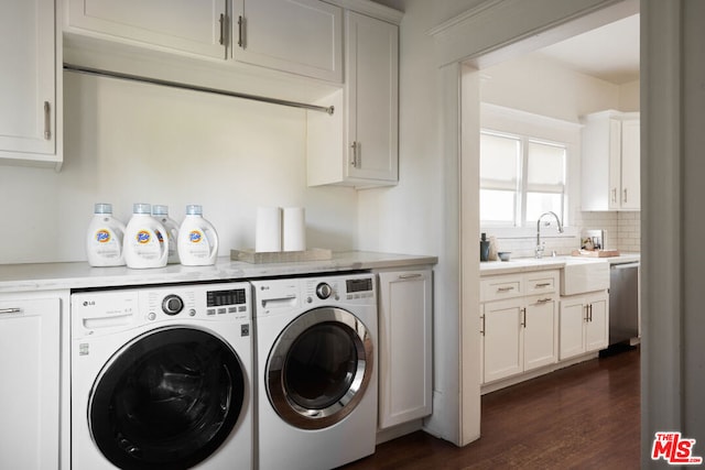 washroom featuring washer and dryer, sink, cabinets, and dark wood-type flooring