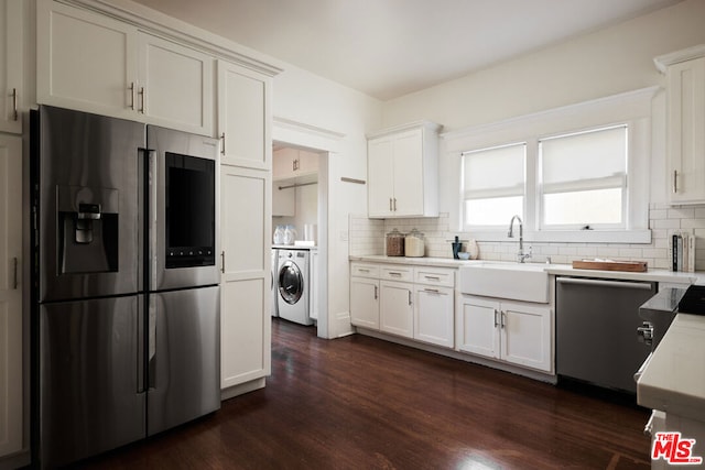 kitchen featuring white cabinets, washer / clothes dryer, appliances with stainless steel finishes, and sink