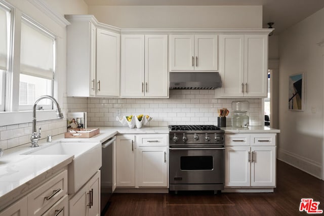 kitchen with white cabinets, appliances with stainless steel finishes, sink, and tasteful backsplash