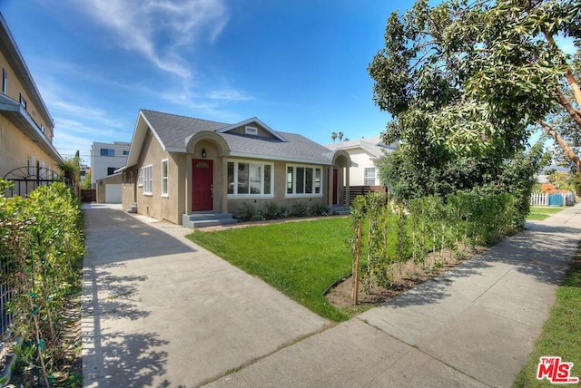 view of front of house with an outbuilding, a front lawn, and a garage