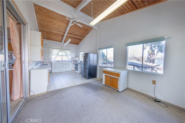 kitchen with light carpet, wood ceiling, fridge, and beamed ceiling