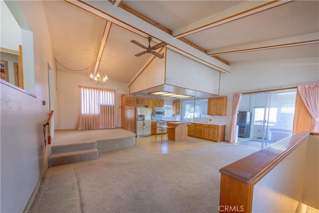 kitchen with beamed ceiling, white fridge with ice dispenser, a wealth of natural light, and high vaulted ceiling