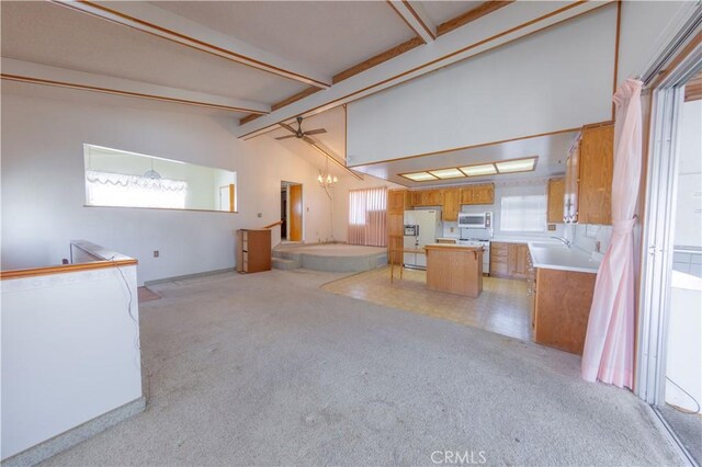 interior space featuring white appliances, vaulted ceiling with beams, light colored carpet, kitchen peninsula, and a chandelier