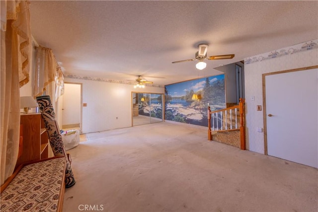 interior space with carpet flooring, a textured ceiling, and ceiling fan