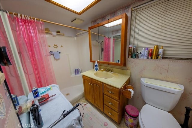 bathroom featuring vanity, curtained shower, and toilet