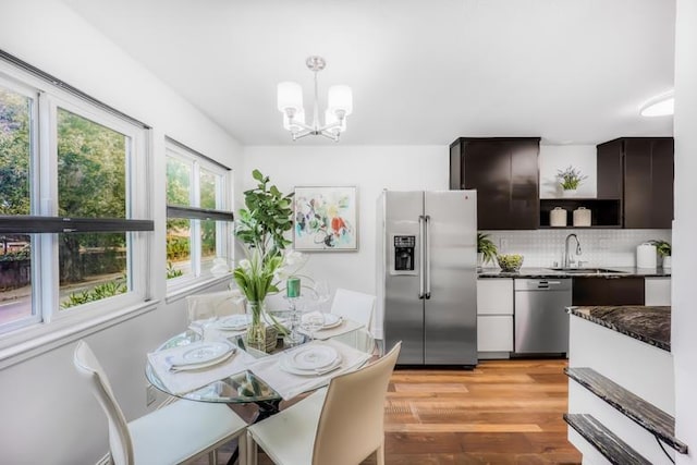 interior space with an inviting chandelier, sink, and light hardwood / wood-style flooring