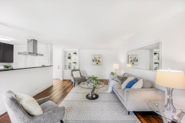 living room featuring hardwood / wood-style floors and built in shelves