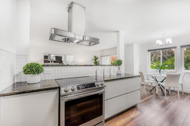 kitchen featuring pendant lighting, white cabinetry, a chandelier, hardwood / wood-style flooring, and stainless steel electric range