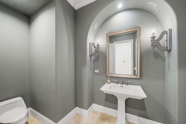 bathroom with toilet and ornamental molding