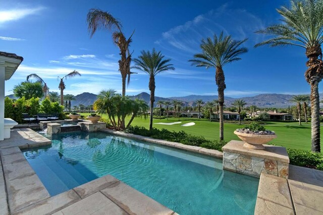 view of pool with a mountain view and a lawn