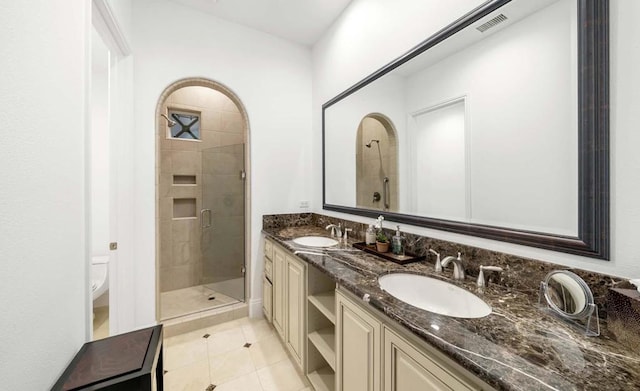 bathroom featuring vanity, toilet, tile patterned flooring, and an enclosed shower