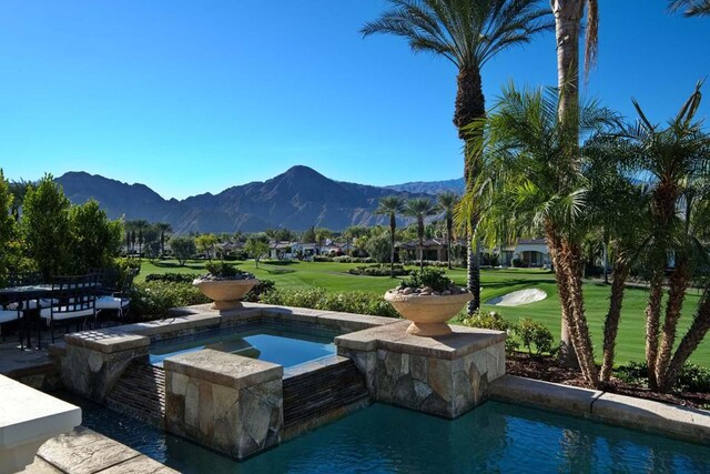 view of pool featuring a yard and a mountain view