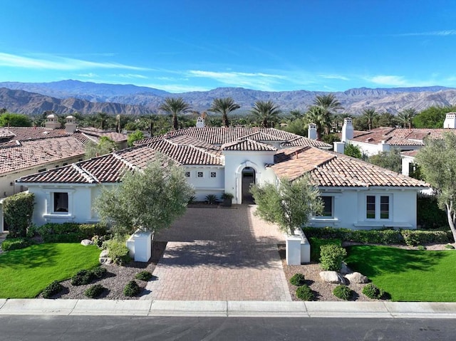 view of front of home with a mountain view and a front lawn