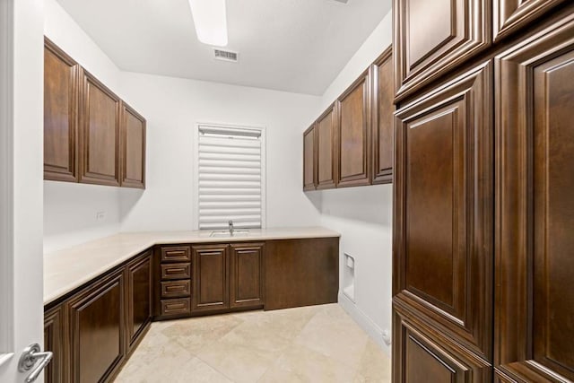 washroom featuring sink, hookup for an electric dryer, and cabinets