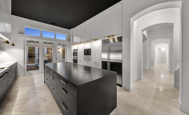 kitchen with white cabinetry, a center island, and built in appliances