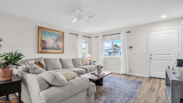 living room featuring ceiling fan and light hardwood / wood-style floors