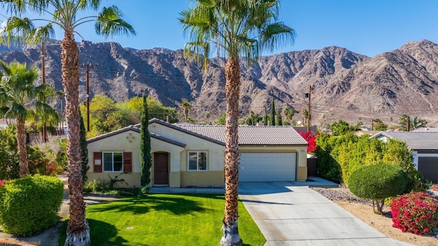 ranch-style home with a garage, a mountain view, and a front yard