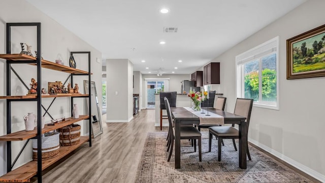 dining area with light hardwood / wood-style flooring and ceiling fan