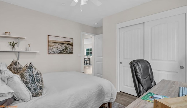 bedroom with dark hardwood / wood-style floors, ceiling fan, and a closet