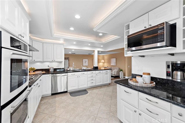 kitchen with white cabinetry, appliances with stainless steel finishes, and a tray ceiling