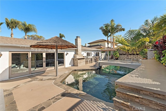 view of pool featuring a patio and exterior kitchen