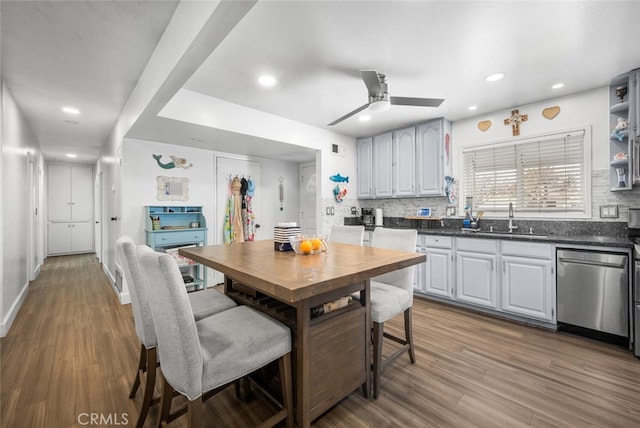 kitchen with ceiling fan, stainless steel dishwasher, hardwood / wood-style floors, and sink