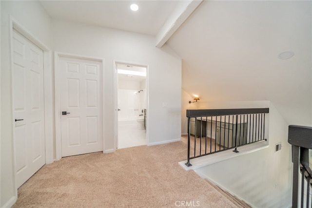 corridor featuring light carpet and vaulted ceiling with beams