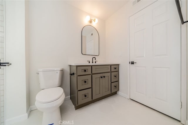 bathroom with toilet, tile patterned flooring, and vanity