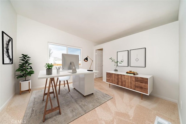 home office with lofted ceiling and light colored carpet