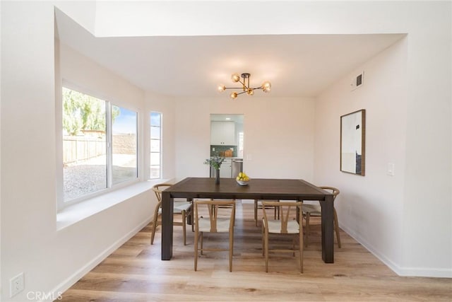 dining space featuring light hardwood / wood-style floors and a chandelier