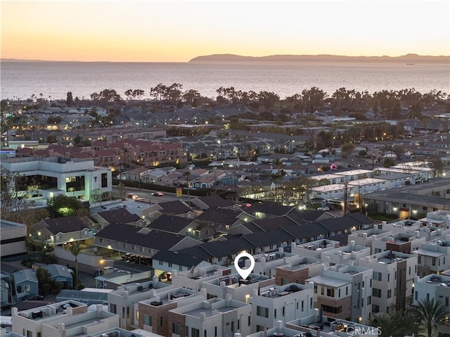 aerial view at dusk featuring a water view