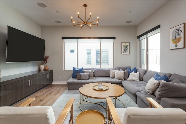 living room featuring a notable chandelier and light wood-type flooring