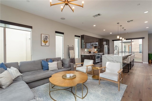 living room with wood-type flooring, sink, and a chandelier