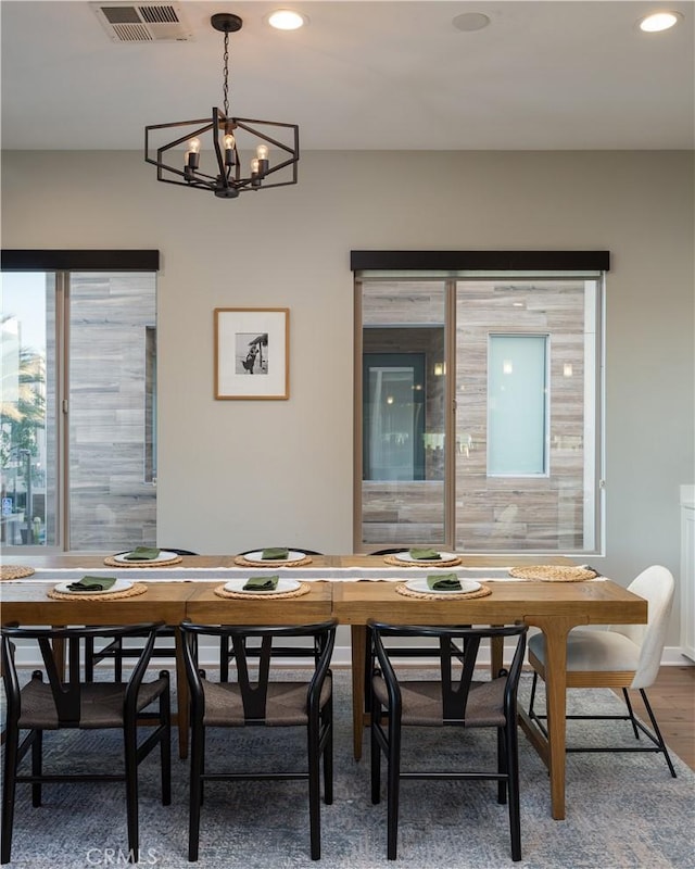 dining space with a notable chandelier and hardwood / wood-style flooring