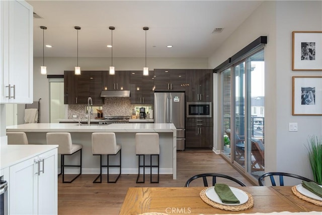 kitchen featuring dark brown cabinets, white cabinets, sink, and stainless steel appliances