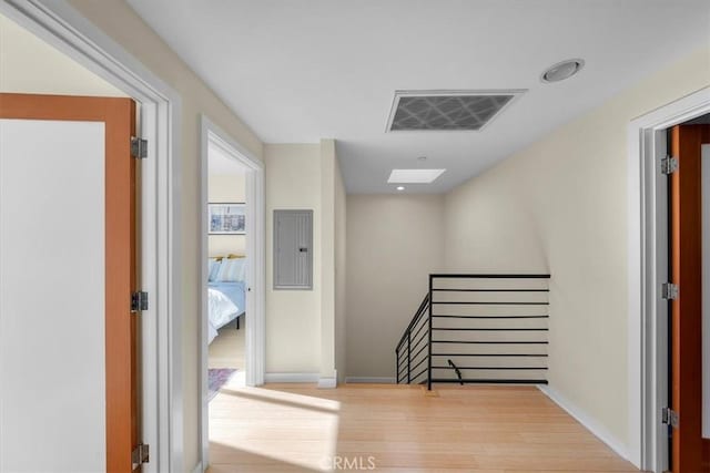 hall featuring electric panel and light hardwood / wood-style flooring