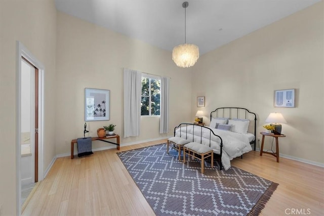 bedroom with an inviting chandelier and light hardwood / wood-style flooring