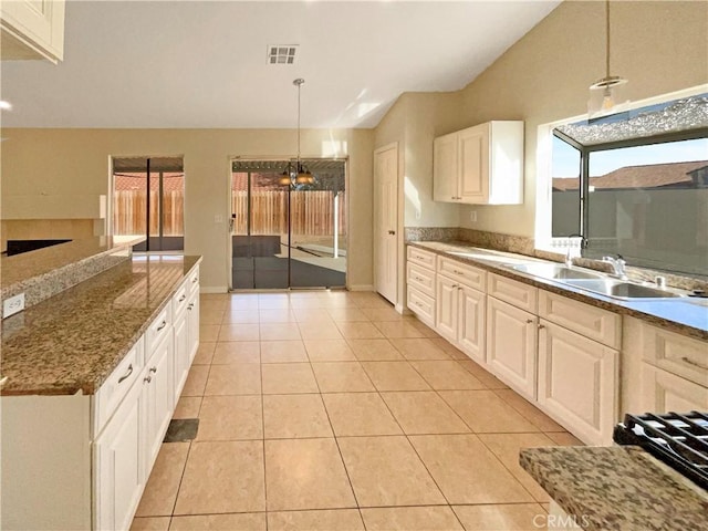 kitchen with white cabinetry, sink, hanging light fixtures, and light tile patterned floors