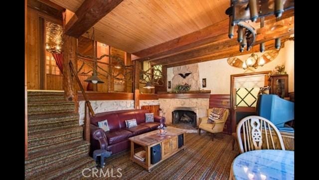 living room with beam ceiling, wood ceiling, and wooden walls