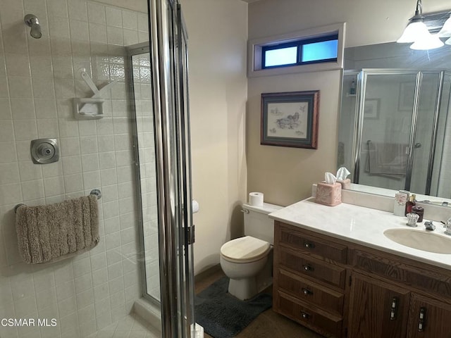 bathroom with toilet, a shower with door, and vanity