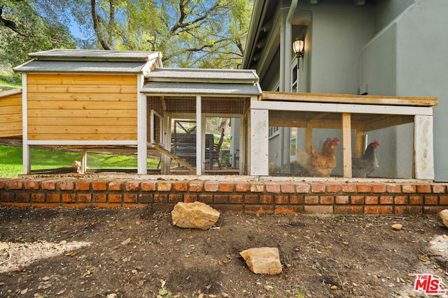 rear view of property with an outdoor structure