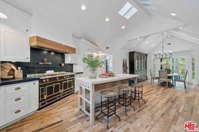 kitchen featuring a skylight, backsplash, and white cabinets