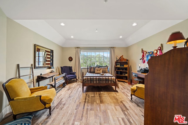 sitting room with a raised ceiling and light hardwood / wood-style flooring